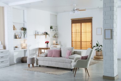 Photo of Comfortable sofa with cushions in room. Interior design