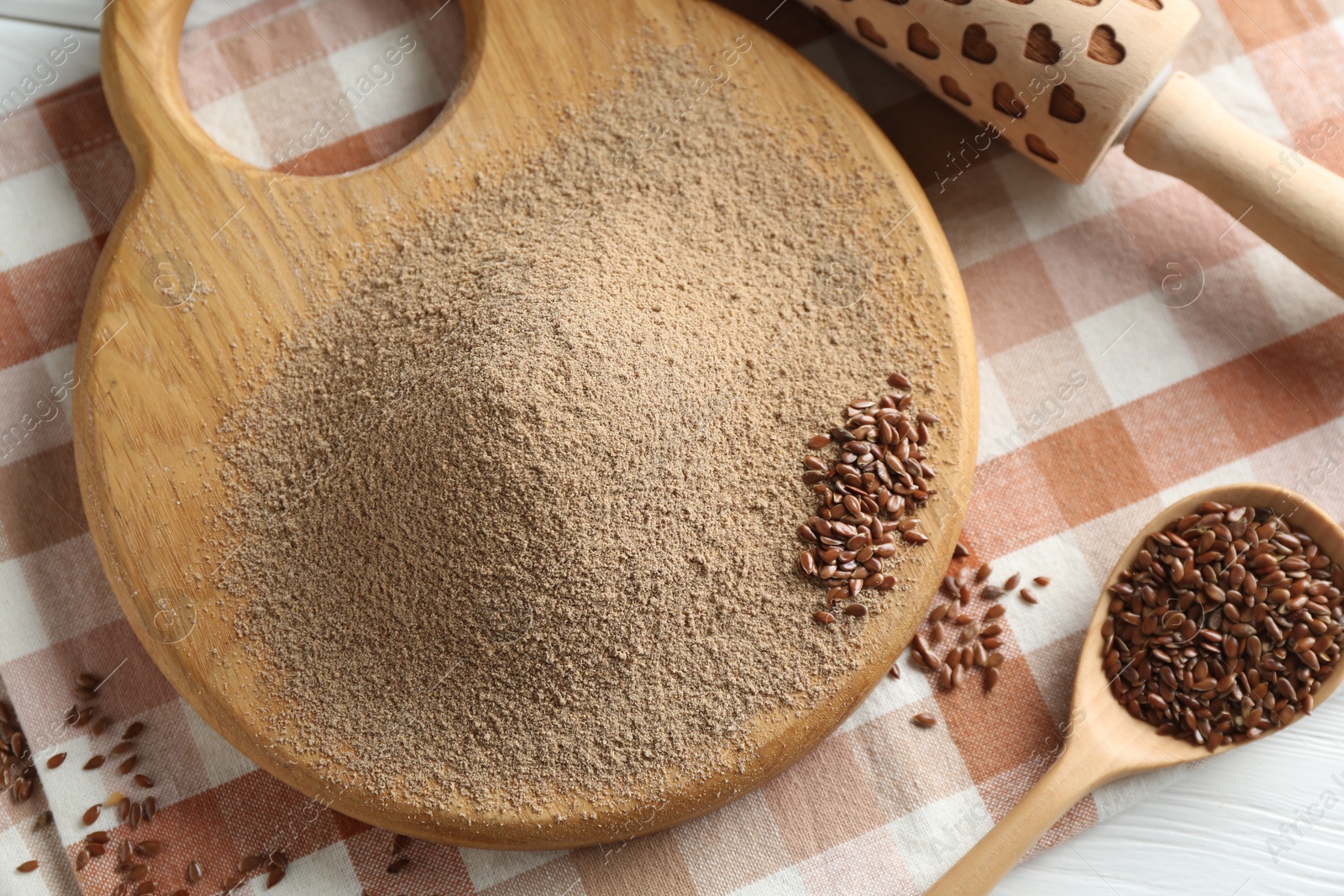 Flaxseed flour, rolling pin and spoon on table, closeup Photo of Flaxseed flour, rolling pin and spoon on table, closeup