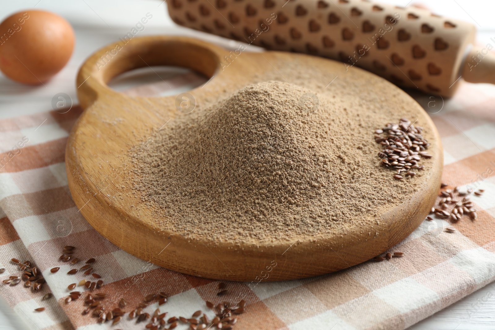 Flaxseed flour, rolling pin and egg on table, closeup Photo of Flaxseed flour, rolling pin and egg on table, closeup