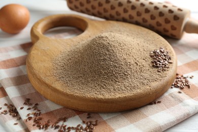 Photo of Flaxseed flour, rolling pin and egg on table, closeup