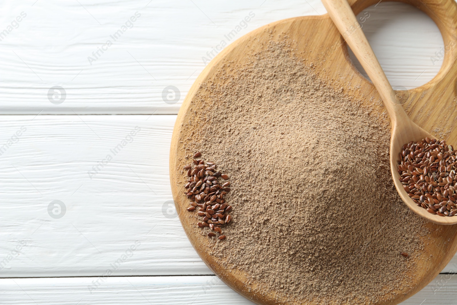 Flaxseed flour and spoon with seeds on white wooden table, top view. Space for text Photo of Flaxseed flour and spoon with seeds on white wooden table, top view. Space for text