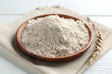 Photo of Flour and spike on white wooden table, closeup