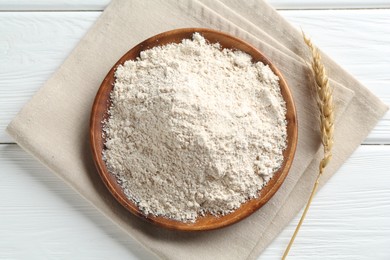 Photo of Flour and spike on white wooden table, flat lay