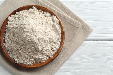 Photo of Flour on white wooden table, top view. Space for text