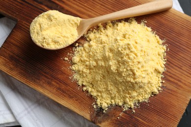 Photo of Pile of corn flour and spoon on table, top view