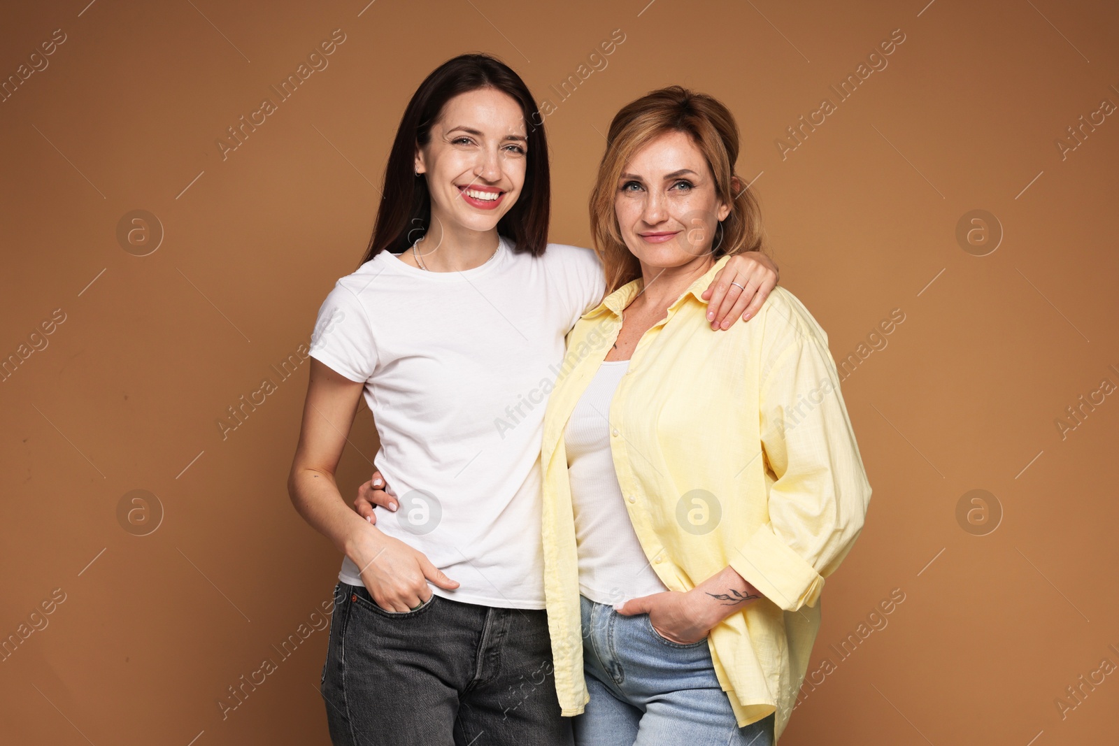 Photo of Portrait of mother and daughter on brown background