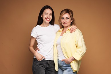 Photo of Portrait of mother and daughter on brown background