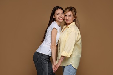 Photo of Portrait of mother and daughter on brown background