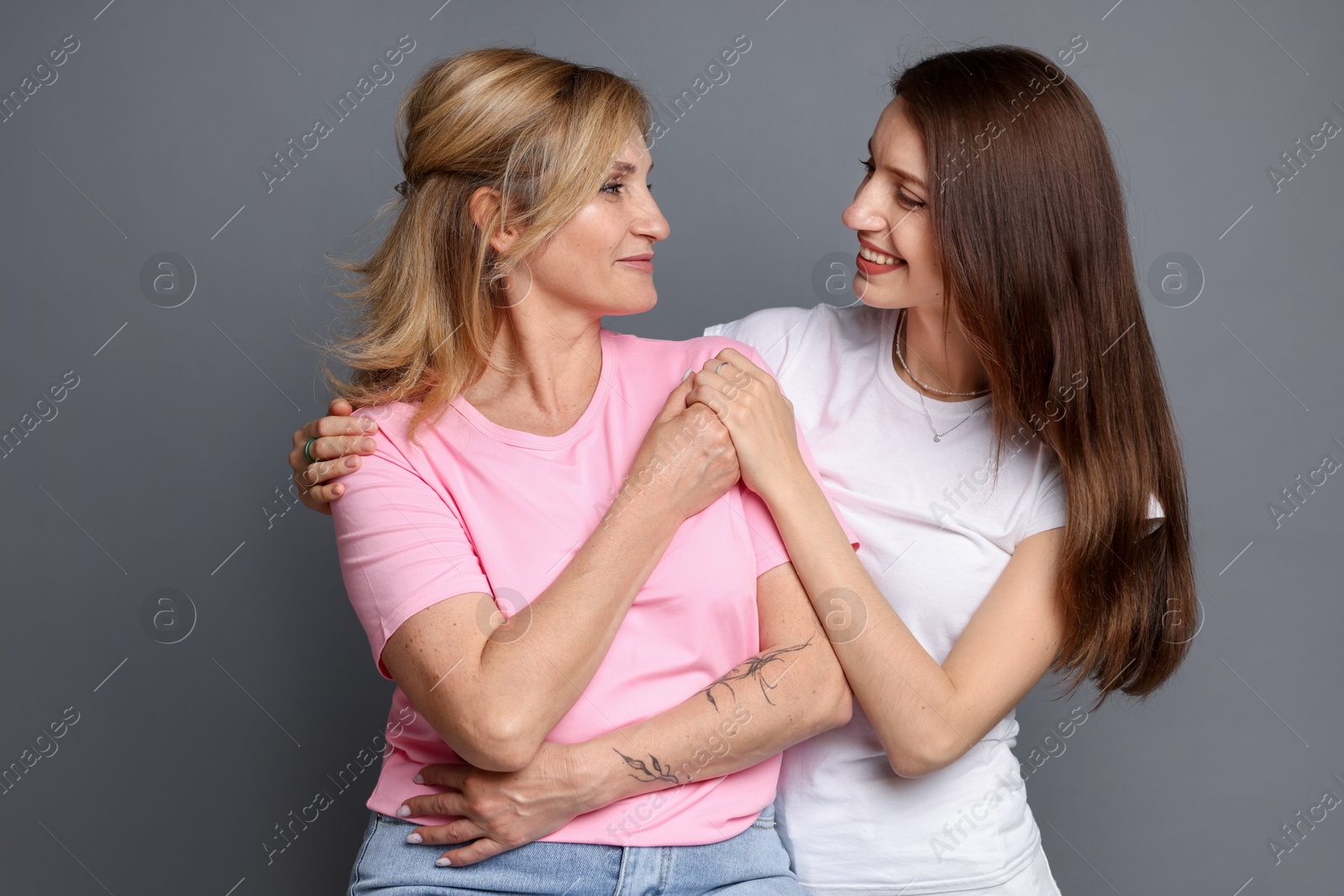 Portrait of mother and daughter on grey background Photo of Portrait of mother and daughter on grey background