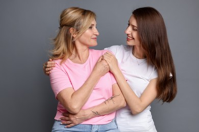 Photo of Portrait of mother and daughter on grey background