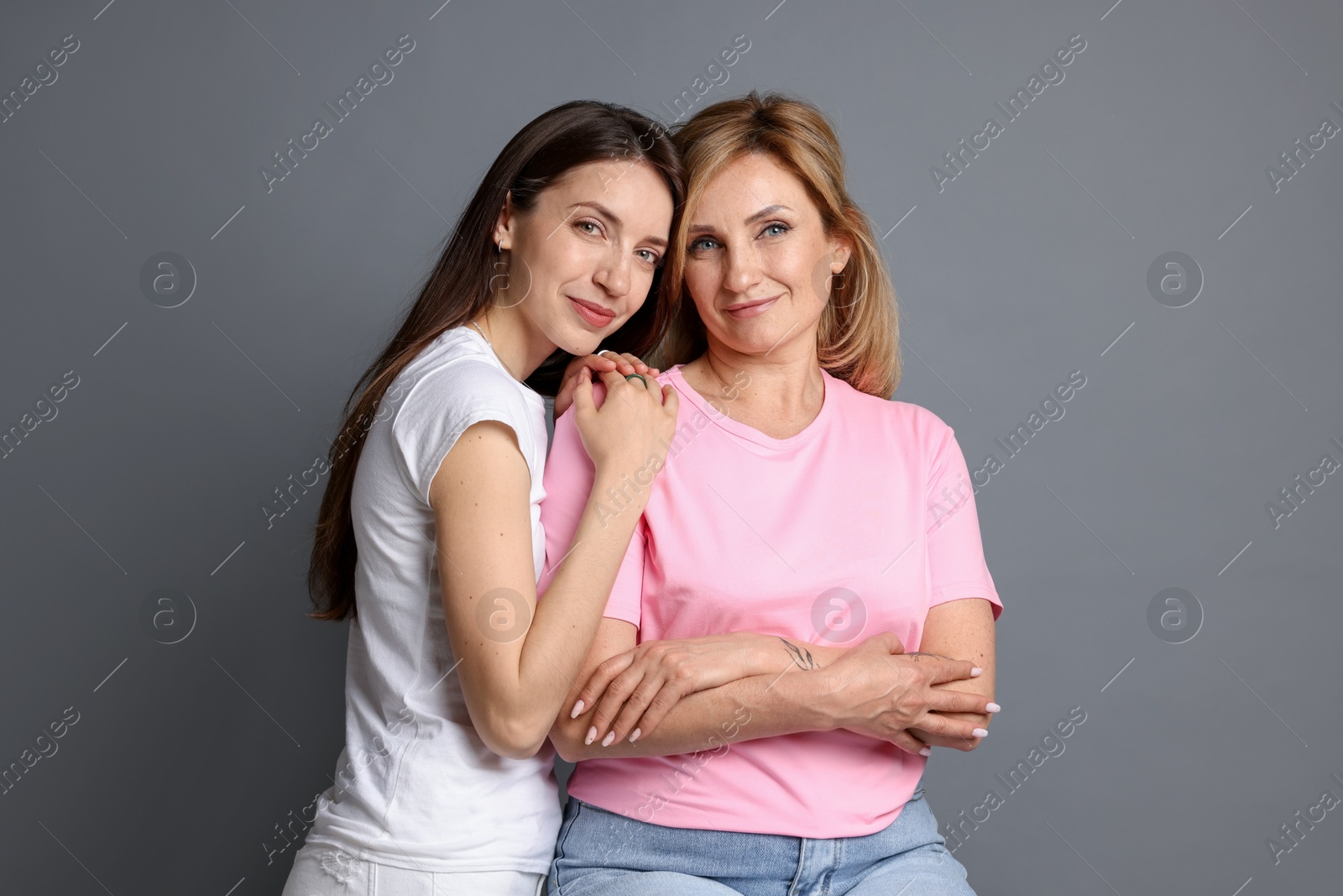 Photo of Portrait of mother and daughter on grey background