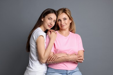 Photo of Portrait of mother and daughter on grey background