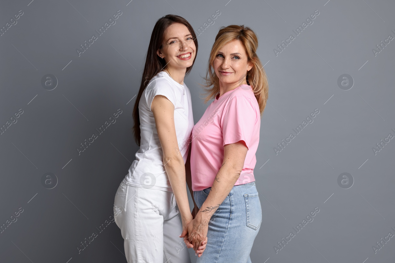 Portrait of mother and daughter on grey background Photo of Portrait of mother and daughter on grey background