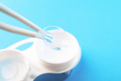 Photo of Taking contact lens from case on light background, closeup. Space for text