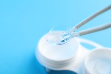 Photo of Taking contact lens from case on light background, closeup. Space for text