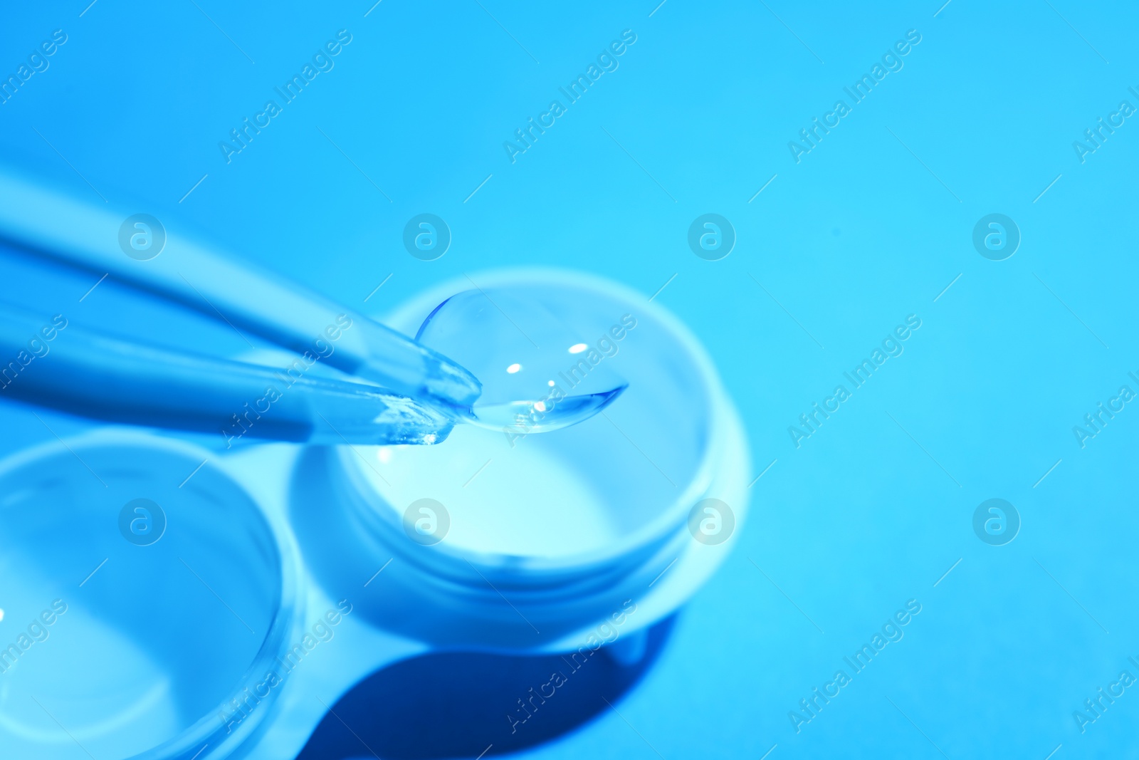 Taking contact lens from case on light background, closeup. Space for text Photo of Taking contact lens from case on light background, closeup. Space for text