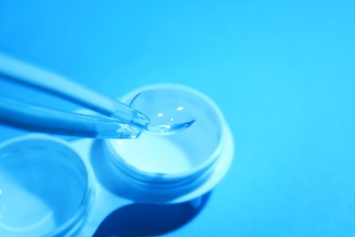 Photo of Taking contact lens from case on light background, closeup. Space for text
