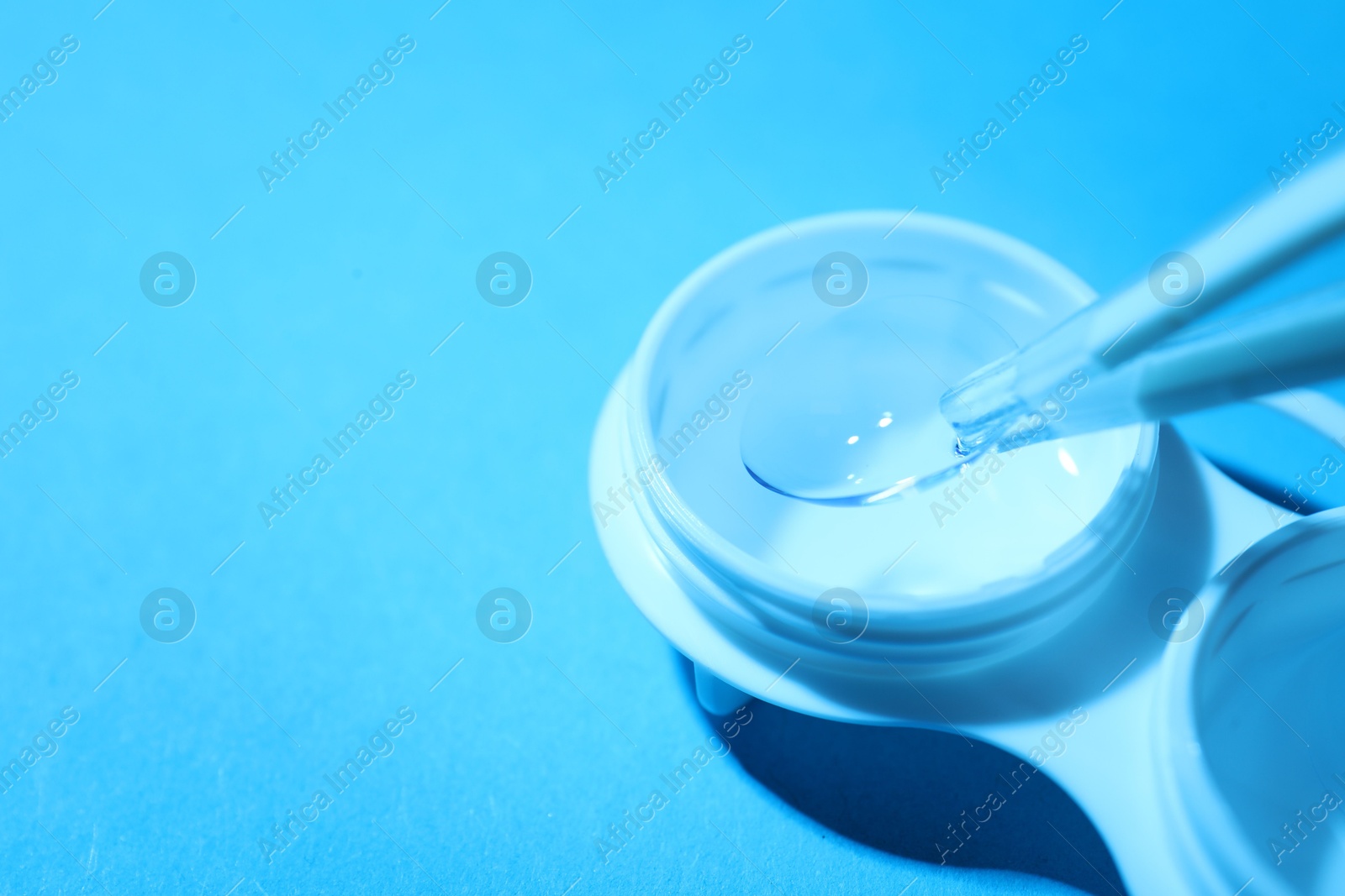 Taking contact lens from case on light background, closeup. Space for text Photo of Taking contact lens from case on light background, closeup. Space for text
