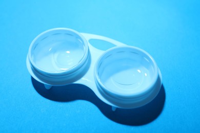 Photo of Contact lenses in case on light blue background, above view