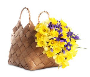 Photo of Bouquet of beautiful daffodils and irises in basket isolated on white