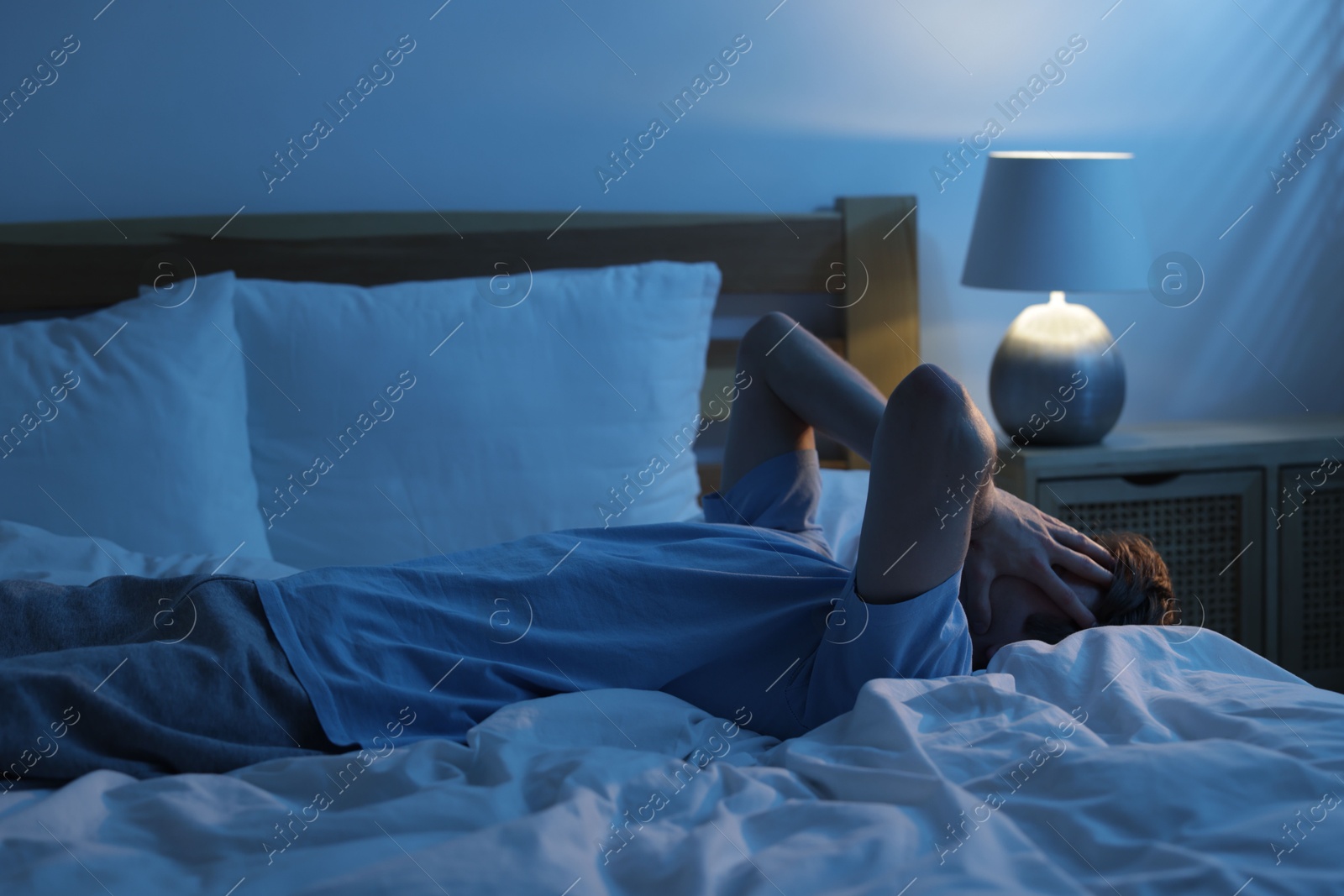 Frustrated man suffering from insomnia on bed indoors Photo of Frustrated man suffering from insomnia on bed indoors