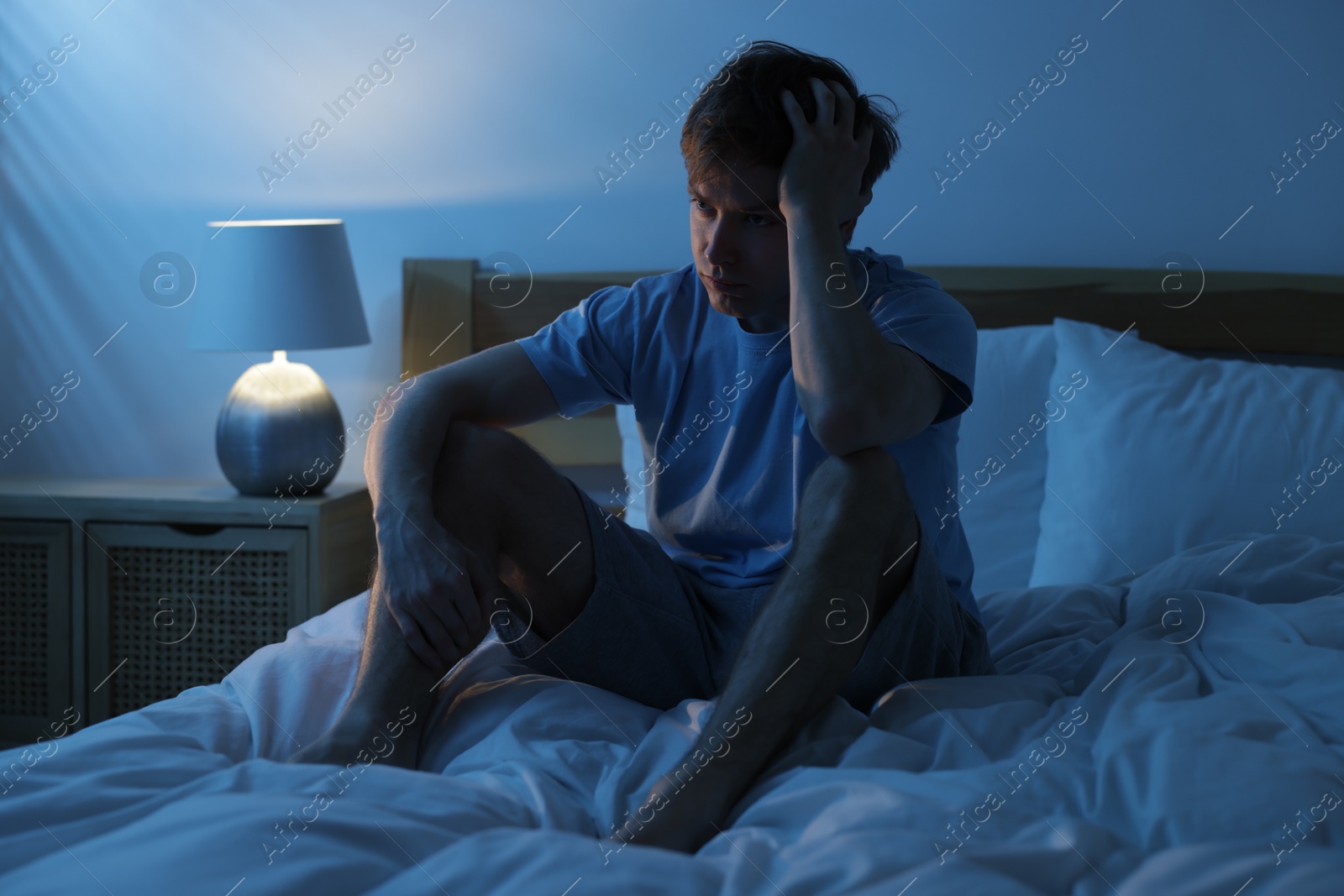 Frustrated man suffering from insomnia on bed indoors Photo of Frustrated man suffering from insomnia on bed indoors