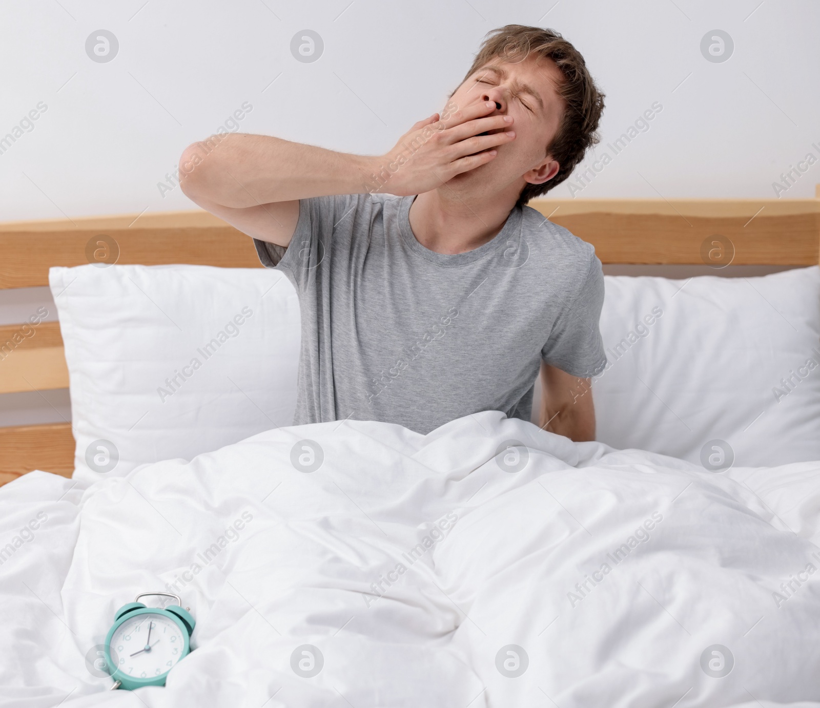 Man yawning in bed indoors. Good morning Photo of Man yawning in bed indoors. Good morning