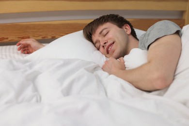 Photo of Smiling man sleeping in bed at home