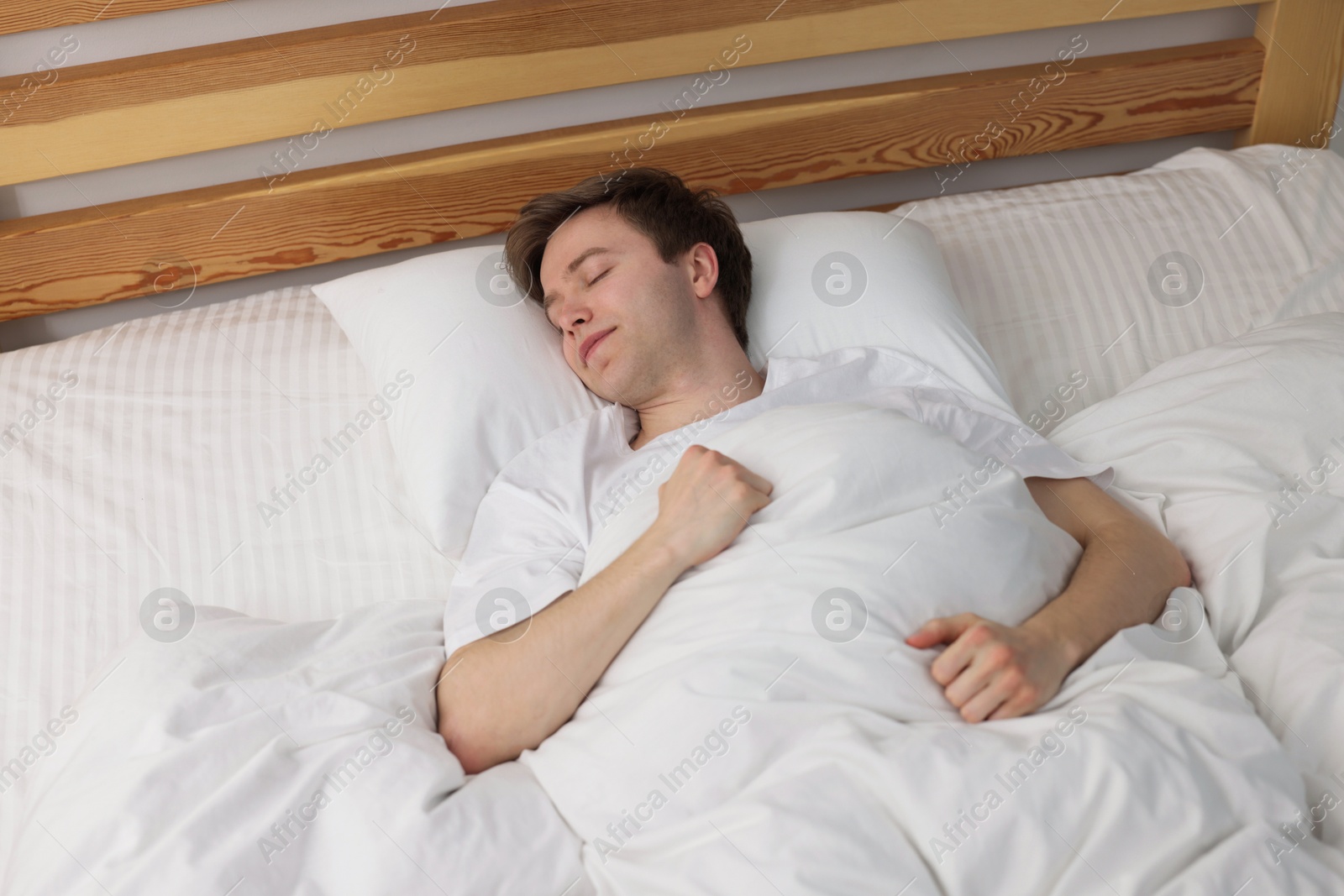 Young man sleeping in bed at home, above view Photo of Young man sleeping in bed at home, above view