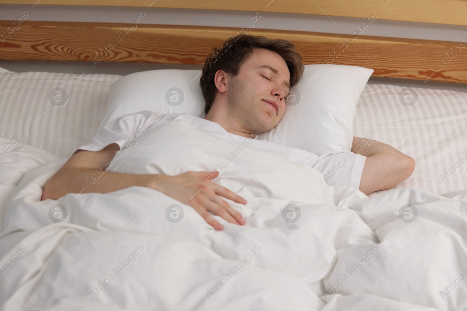 Young man sleeping in bed at home Photo of Young man sleeping in bed at home