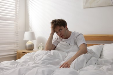 Photo of Tired man suffering from insomnia in bed indoors