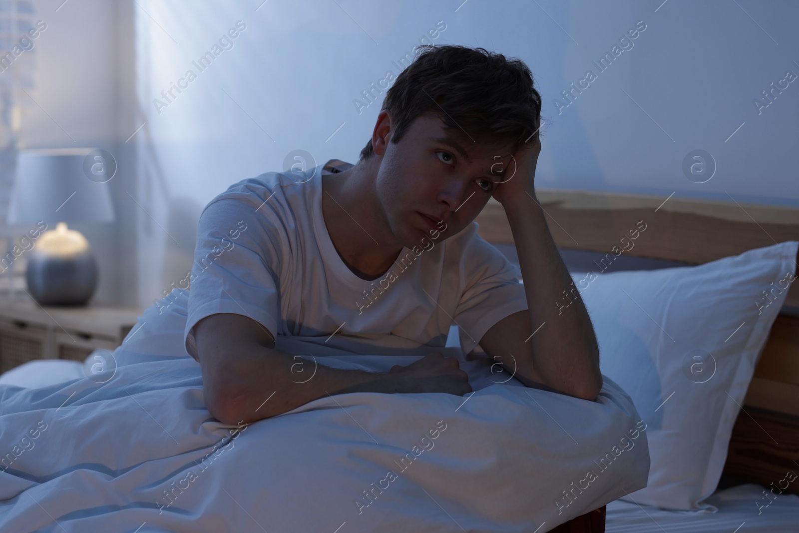 Frustrated man suffering from insomnia on bed indoors Photo of Frustrated man suffering from insomnia on bed indoors