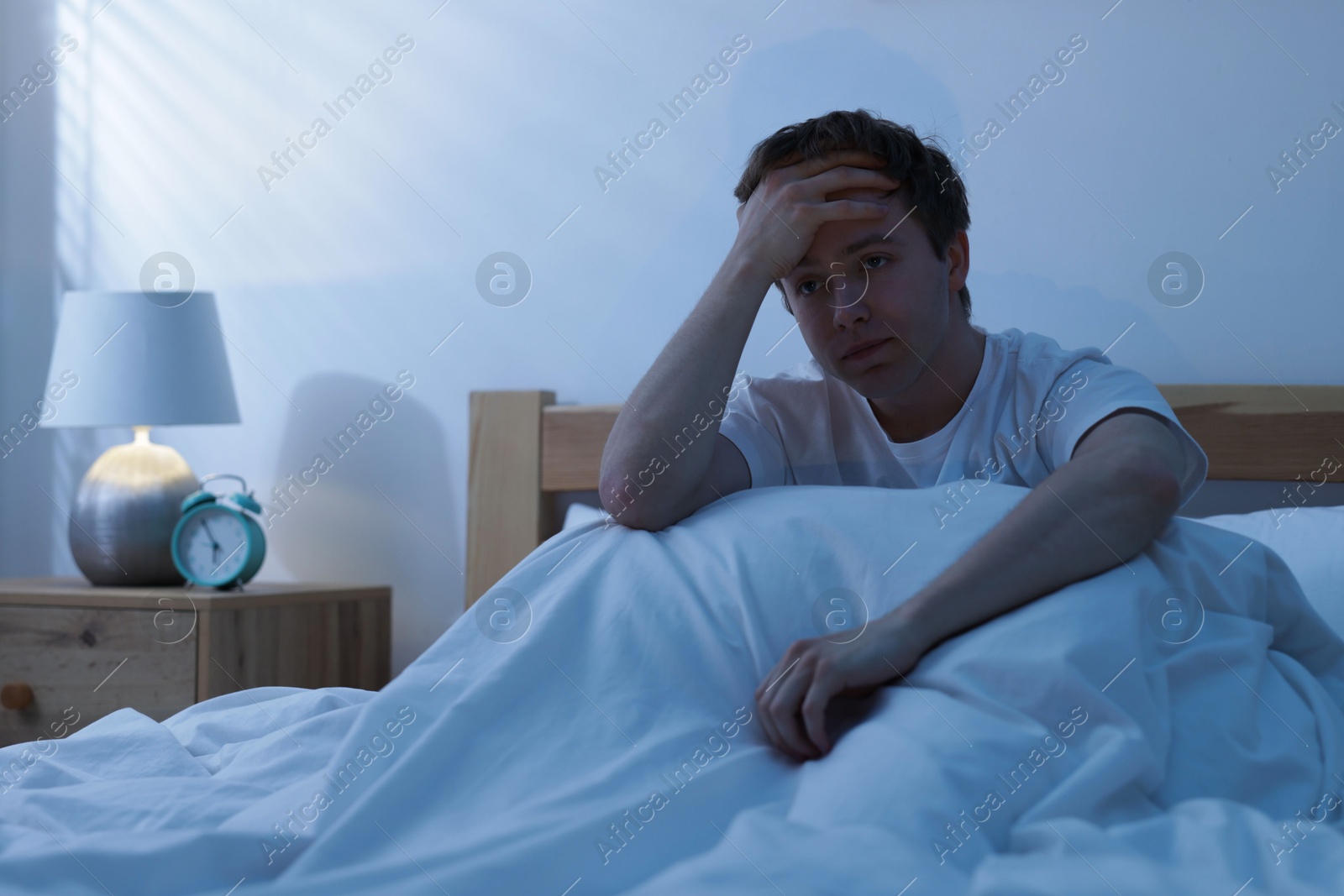 Frustrated man suffering from insomnia in bed indoors Photo of Frustrated man suffering from insomnia in bed indoors