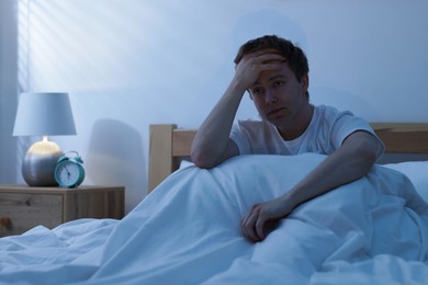 Photo of Frustrated man suffering from insomnia in bed indoors