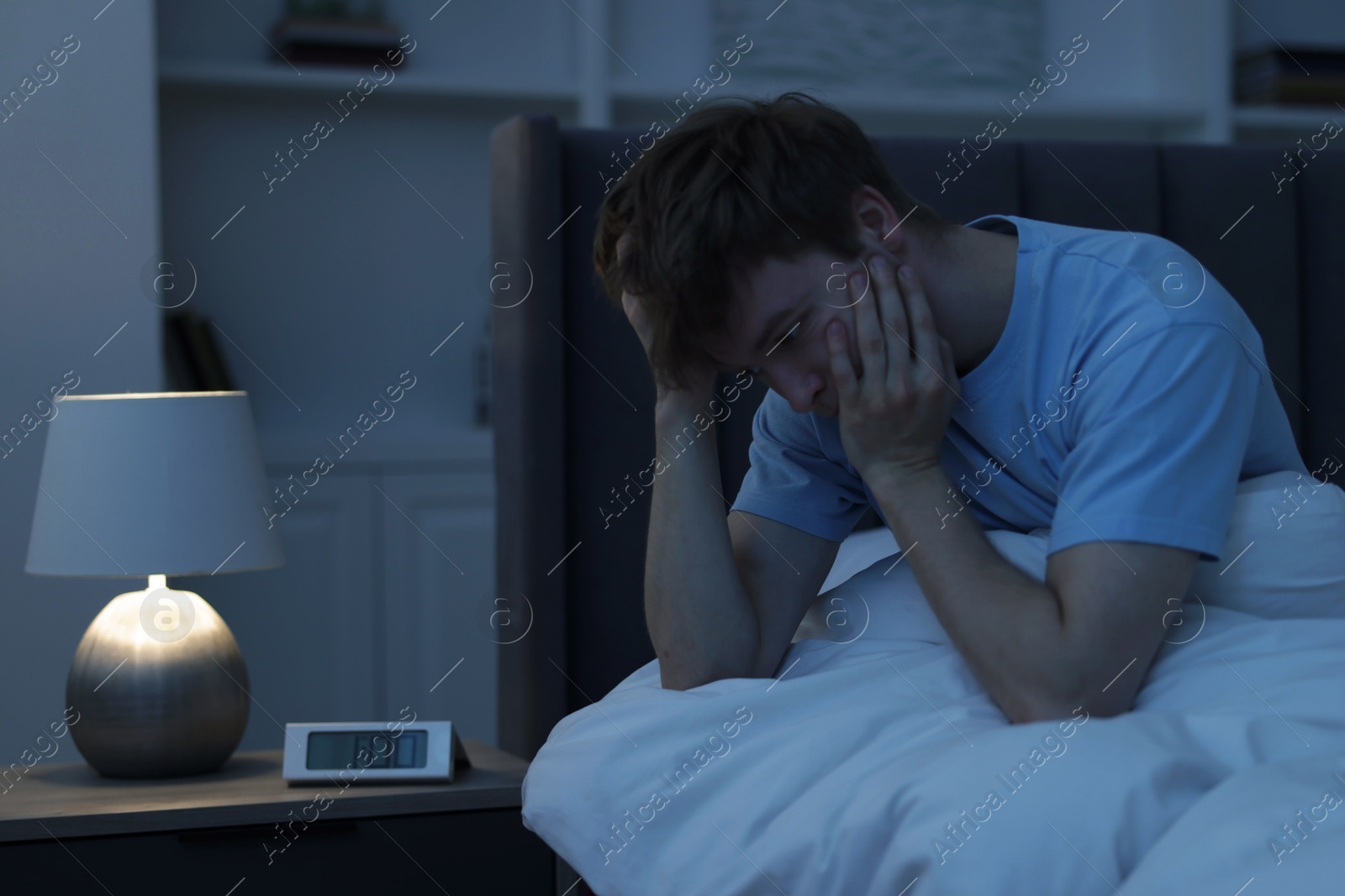 Frustrated man suffering from insomnia on bed indoors Photo of Frustrated man suffering from insomnia on bed indoors