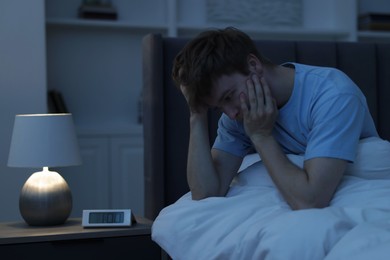 Photo of Frustrated man suffering from insomnia on bed indoors