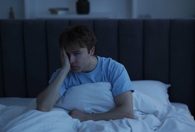 Photo of Frustrated man suffering from insomnia in bed indoors