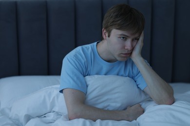 Photo of Frustrated man suffering from insomnia in bed indoors