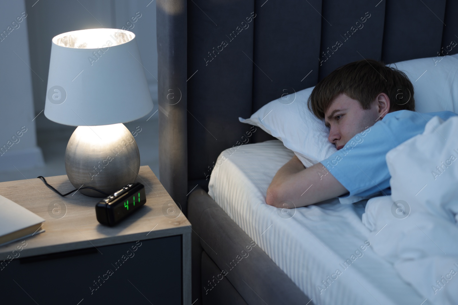Frustrated man suffering from insomnia on bed indoors Photo of Frustrated man suffering from insomnia on bed indoors