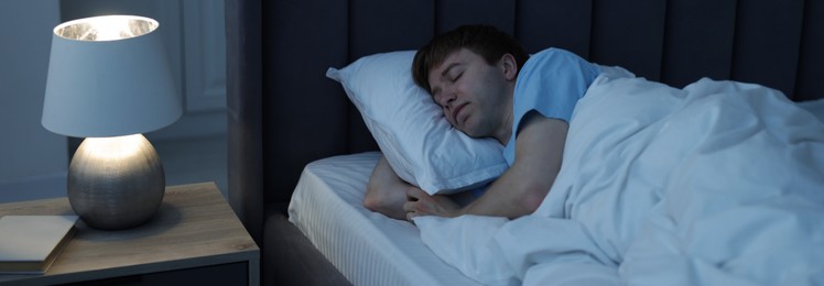 Photo of Young man sleeping in bed at home