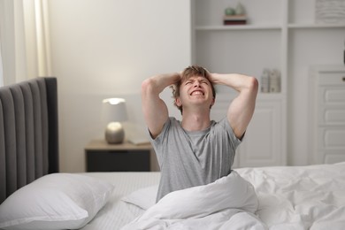 Photo of Emotional overslept man in bed at home