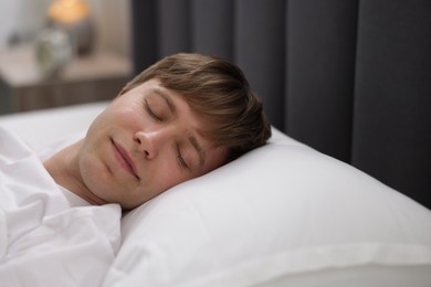 Photo of Young man sleeping in bed at home, closeup