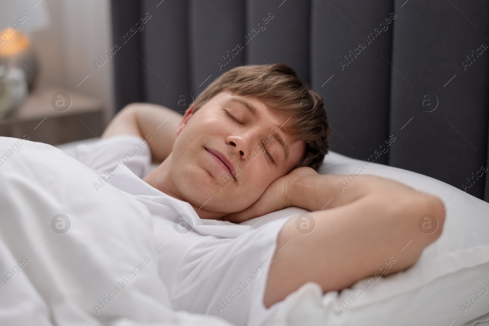Young man sleeping in bed at home, closeup Photo of Young man sleeping in bed at home, closeup