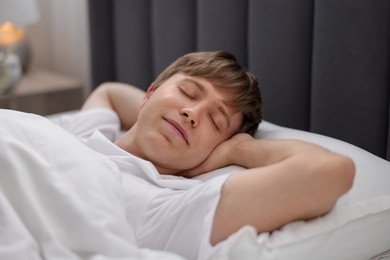 Photo of Young man sleeping in bed at home, closeup