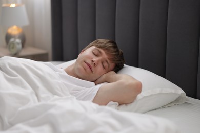 Photo of Young man sleeping in bed at home