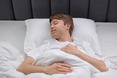 Photo of Young man sleeping in bed at home