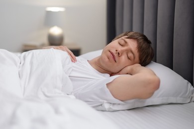 Photo of Young man sleeping in bed at home