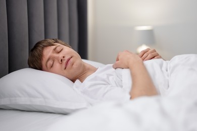 Photo of Young man sleeping in bed at home
