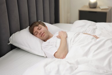Photo of Young man sleeping in bed at home