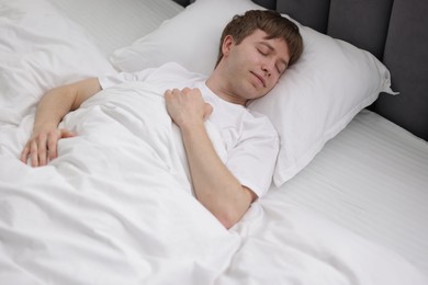 Photo of Young man sleeping in bed at home